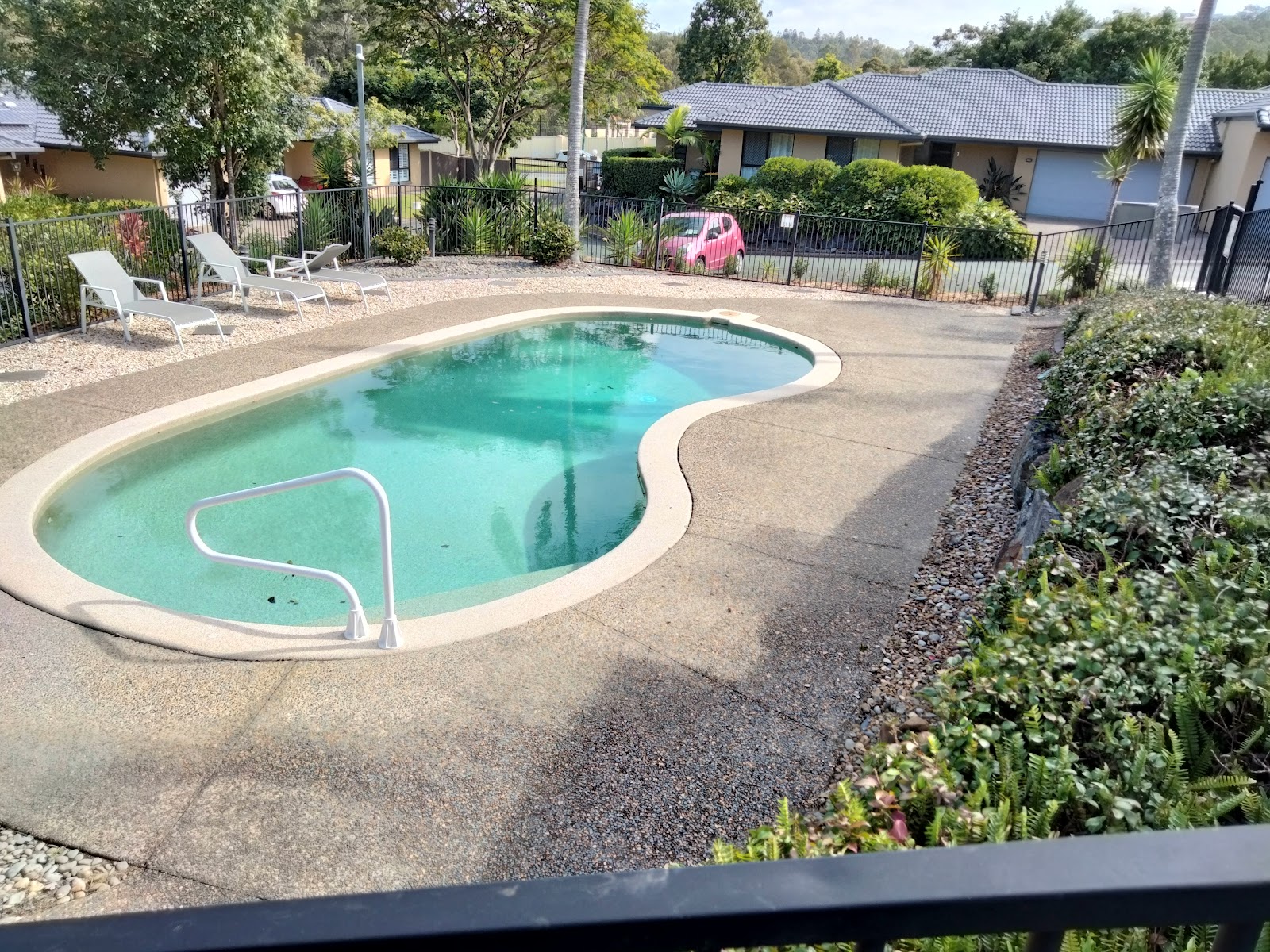 Pool surrounds with a pebble border and neatly planted edges